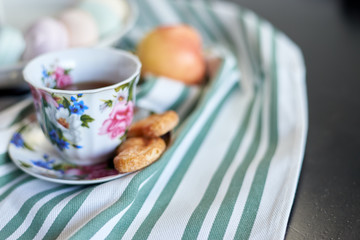 tea, marshmallows and cookies, an apple on a striped towel