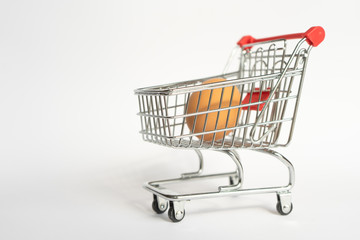 toy little consumer food trolley from steel with red plastic handle on a gray background with one fresh egg inside. empty space