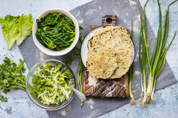 Flatbread with greens and herbs.   Traditional caucasus and Turkish bread. Spinach and detox fresh vegetables cabbage salad. Vegan food