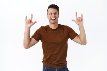 Fototapeta premium Lifestyle, leisure and people concept. Charismatic, handsome smiling adult man having fun on awesome music festival, enjoying great sound quality, show rock-n-roll heavy metal sign and dancing