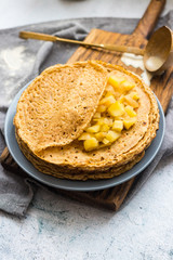 Homemade golden crepes or thin pancakes stuffed with sweet cooked apples. Vegan dessert.