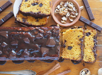 Close-up.Holiday homemade chocolate pumpkin long rectangular cupcake, glazed with chocolate, ready to eat on a kitchen board.Wooden background.