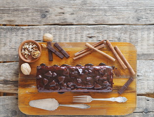 Place for text. Holiday homemade chocolate pumpkin long rectangular cupcake, glazed with chocolate, ready to eat on a kitchen board.