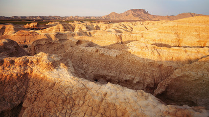 Landscape of small mountains of land with iron oxides, between which a river runs in the north of Spain. It is the desert of Las Bardenas Reales in Navarra.