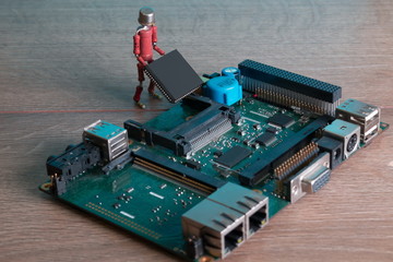 small human figure, made from resistors and transistor, helps to fix electronic computer board