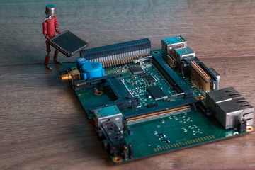 small human figure, made from resistors and transistor, helps to fix electronic computer board