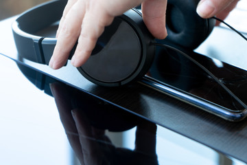 white hands hold black headphones, phone, tablet-technology in isolation, quarantine, COVID-19