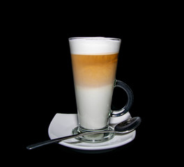 a finished triple layered latte coffee served with plate and spoon 