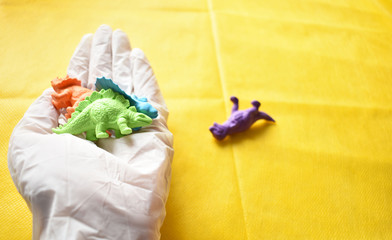 hand with different dinosaurs on yellow