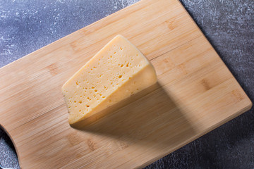 Grated piece of milk yellow cheese. The aroma of delicious cheese.