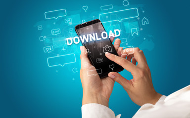 Female hand typing on smartphone with DOWNLOAD inscription, social media concept
