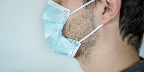 Man putting on a surgical mask