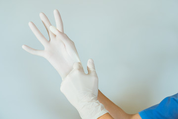 healthcare professional putting on surgical latex gloves