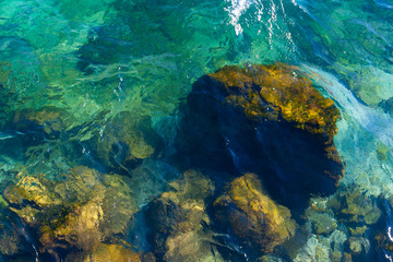 Just below the surface of the lake you can see stones and rocks of different sizes. The crystal water enhances the colors of the dolomite and the granite, with green, brown, gray and blue shades.