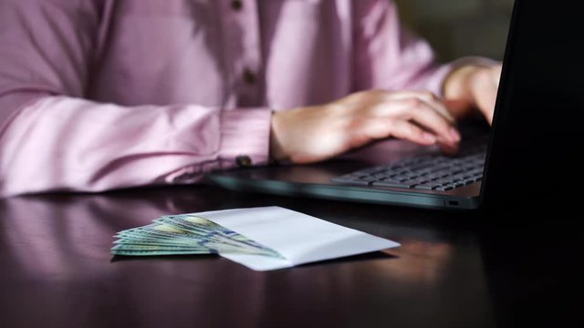 Business woman working on laptop and receiving cash money