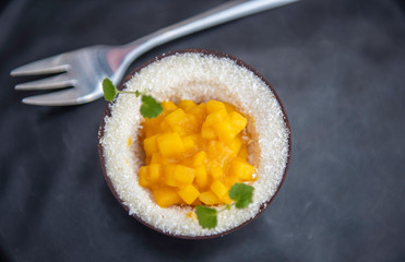 delicious mango coconut frozen summer healthy vegan organic fruit dessert in eadibly chocolate bowl 