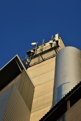 Mobile antennas on an industrial building with a blue sky