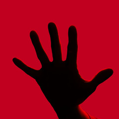 Obraz premium Hand showing sign on red background. Stop.