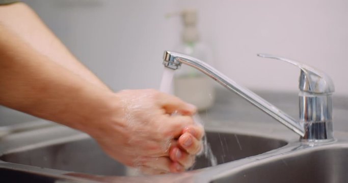 Man Washing Hands in Sink