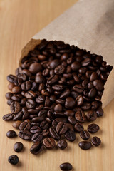 Graos de cafe em um pequeno saco de papel