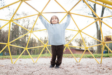 Kids playing on playground walking and climbing on monkey bars