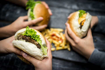 Friends sitting and eating burger