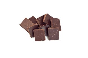 squares of dark chocolate stand one after the other in a scattering