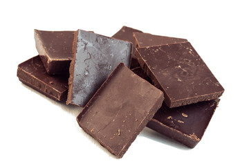 squares of dark brown chocolate are scattered on top of each other