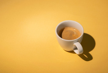Espresso coffee in white cup on golden table. Pop art minimal flat lay creative composition