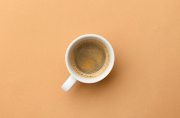 Espresso coffee in white cup on beige table. Pop art minimal flat lay creative composition