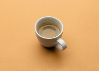 Espresso coffee in white cup on beige table. Pop art minimal flat lay creative composition