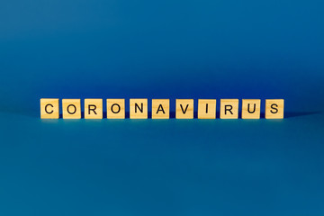 The Concept Of Coronavirus. Prevent or stop the spread of COVID-19 worldwide. Wooden letters on a blue background