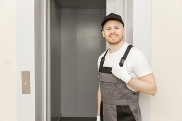 Lift machinist man repairing elevator fixing or adjusting mechanism © Parilov