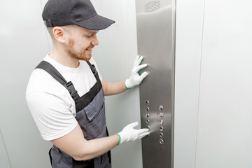 Lift machinist man repairing elevator fixing or adjusting mechanism © Parilov