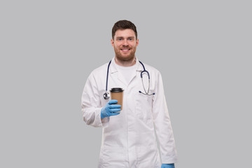 Doctor Showing Coffe To go Cup Wearing Gloves and Smiling Isolated