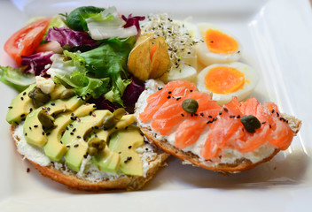 food, fried eggs with toast and mousse and salmon and avocados on a plate