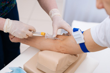 Nurse drawing blood sample from arm for blood test, close-up. Phlebotomist technician drawing blood...