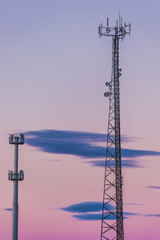 Obraz premium Silhouette in a pair of large transmission towers at sunset