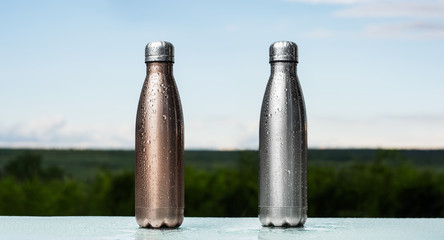 Set of eco reusable thermo bottles with plug, sprayed with water. Bronze and silver of color....