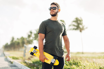 Portrait of skater man on the beach enjoying a sunny day