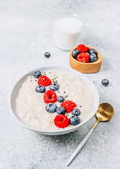 Breakfast oatmeal porridge with fresh berries and almond milk. Healthy vegan food concept. Top view. Copy space. Flat lay