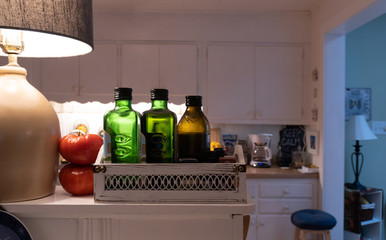 Glass bottles of healthy olive oil aligned on a home shelf in the kitchen