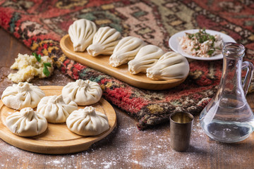 Obraz na płótnie Canvas Georgian dumplings Khinkali with potato and mushroom, Vegan food, Georgian Chacha (vodka) on a wooden background
