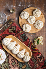Obraz na płótnie Canvas Georgian dumpling or Khinkali. Georgian homemade khinkali with mushroom and potato on cutting board. Vegan food. Top view, copy space for text