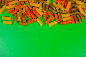 different color pasta on a green background