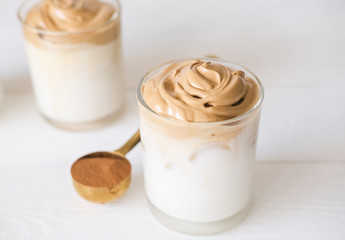 Iced frothy Dalgona Coffee, a trendy fluffy creamy whipped coffee. Korean drink latte espresso with coffee foam. made of instant coffee, sugar, hot water and milk.