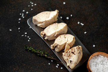 chicken breast on a knife with spices on a stone background
with copy space for your text.