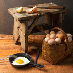 fresh organic village eggs on wooden table, healthy food,  village food. black pan with fried egg. small bench background