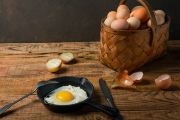 fresh organic village eggs on wooden table, healthy food,  village food. black pan with fried egg. small bench background