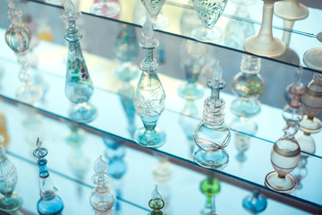 A lot of beautiful empty arabic style glass bottles for perfume in the shop behind the glass